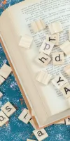 Lettre de scrabble en bois sur un livre ouvert