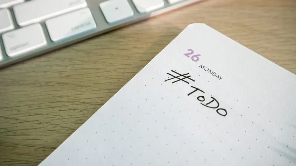 Un carnet ouvert sur une page datée du lundi 26 montre une liste de tâches avec l’inscription « To Do ».